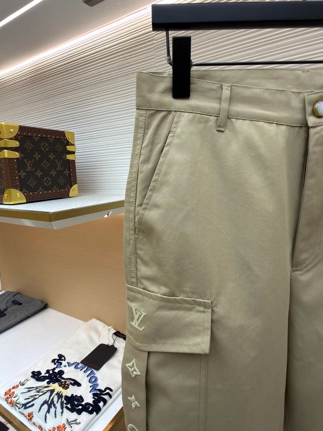 LOUIS VUITTON pocket embroidered work trousers ●Original version: Purchased and developed by 11318 ●Item number: 1681826-B50 ●Fabric: cotton twill fabric ●Technology: embroidery production ●Color: Khaki ●Version: Fitted version ●Weight: about 505 grams ●Size: 44-46-48-50 ●Description: The high cotton content ensures the fabric's excellent breathability, durability and classic workwear texture, while the twill weave gives it unique wear resistance and stiffness. The special fabric technology solves the pain points of tight and stiff traditional overalls; it provides greater freedom when moving, significantly improves wearing comfort and flexibility, and achieves a balance between function and comfort. The application of three-dimensional core-spinning embroidery technology in the pocket position is achieved by adding additional cotton thread or foam as the core material to the pattern filling layer, and then using embroidery thread to fully cover the embroidery. The logo pattern is significantly protruded from the surface of the fabric, forming a full three-dimensional effect. This process not only enhances the visual impact and tactile level, but also improves the wear resistance of the pocket area through the buffering effect of the core material, ensuring that the pattern can still remain crisp and not deformed in complex daily use, ensuring that the pattern is clear and durable, and injecting a sense of sophistication into the rugged workwear style. Diversified pocket system combines workwear functionality with sophistication. The flap cargo pockets on both sides are a signature element, and their flap design prevents items from falling and enhances the visual three-dimensionality. Italian style pockets provide simple side storage. The overall wiring is straight and delicate, the fabric is comfortable and soft, and the color is consistent without color difference. It can be matched with the same style to create a fashionable look and control various occasions. Customized accessories, complete with three standards, same style for men and women!
